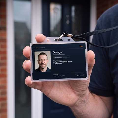 A hand holding up a Trulox ID card at a front door.