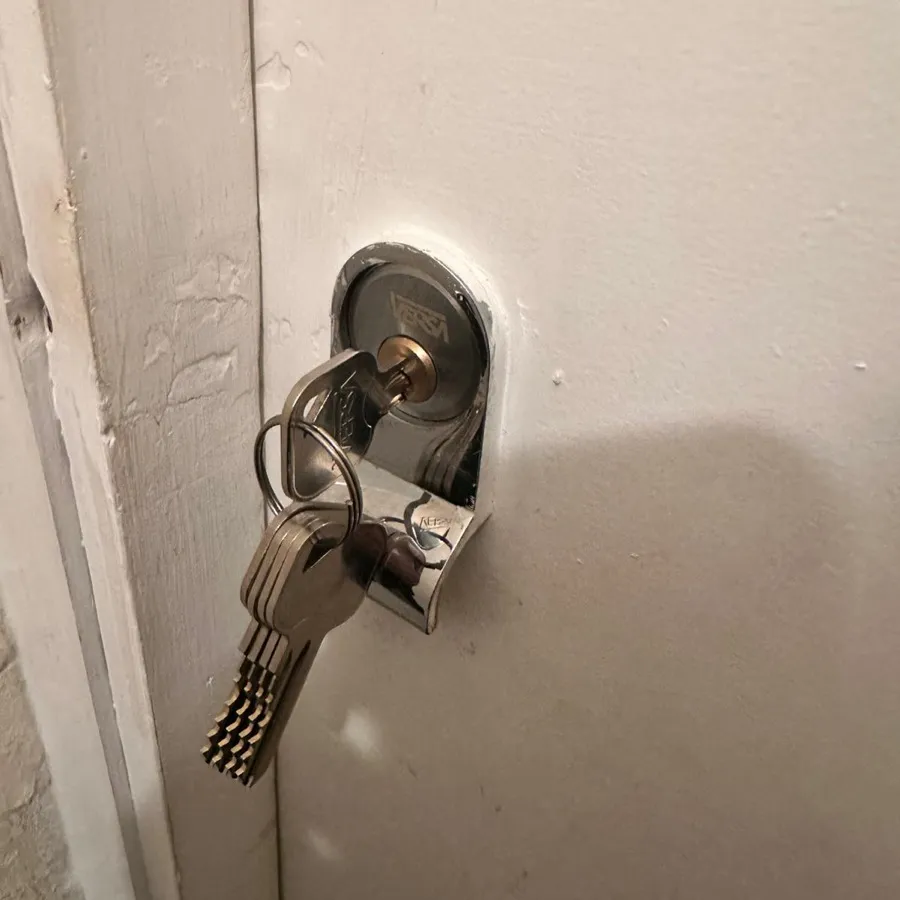 A replacement rim cylinder on a flat front door, new keys still in the lock